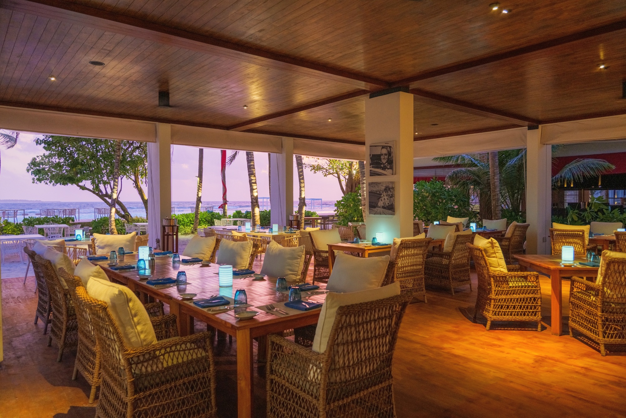 Dining at the water's edge. A table set for two, the Baa Atoll at dusk, the kind of occasion the resort is built around.
