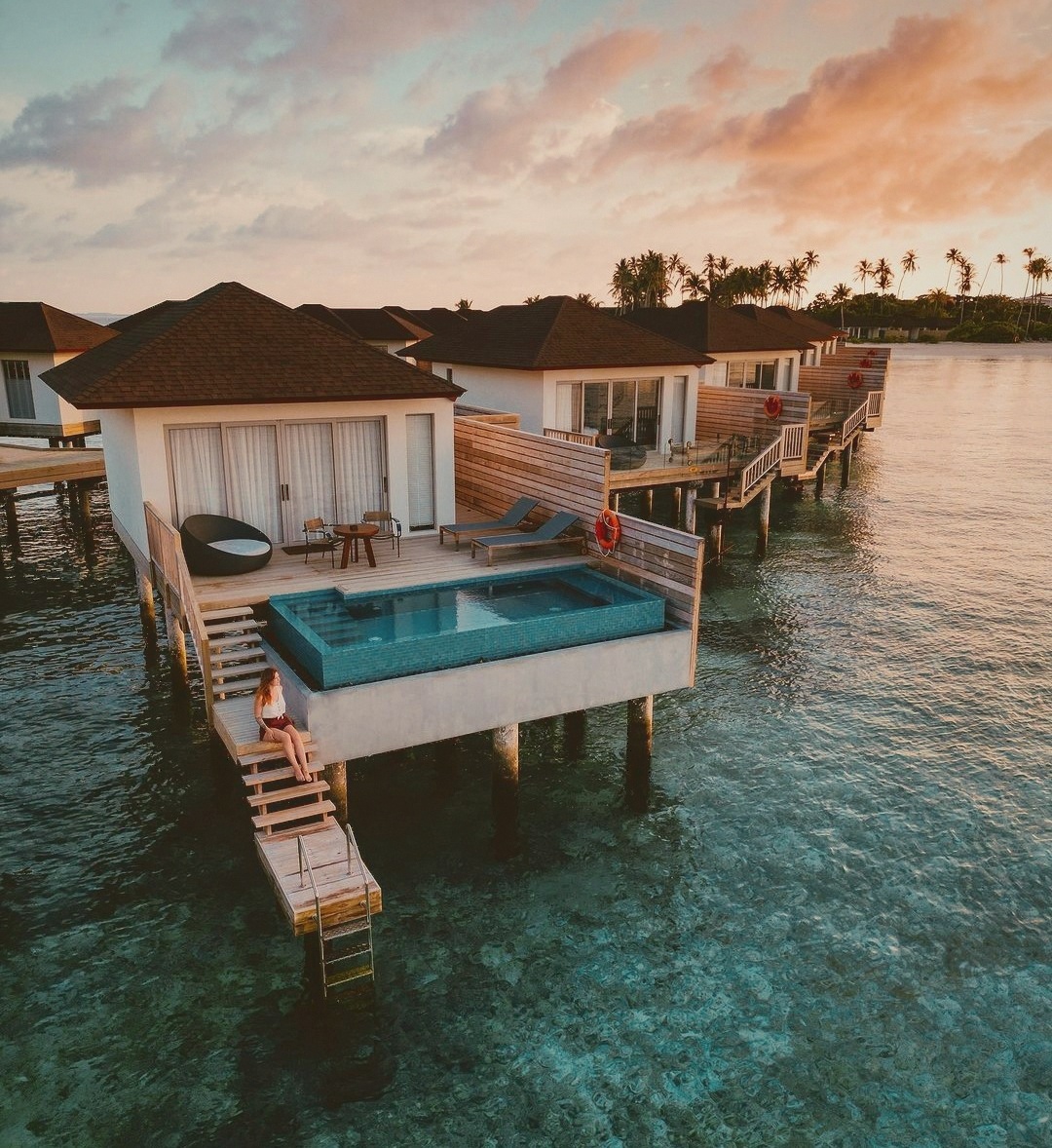 An overwater villa extending above the lagoon. The deck and water entry are the primary living space for most of the day.
