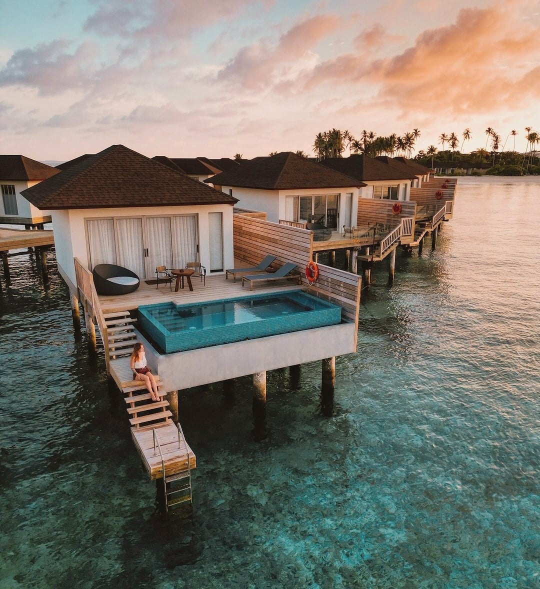 An overwater villa extending above the lagoon. The deck and water entry are the primary living space for most of the day.