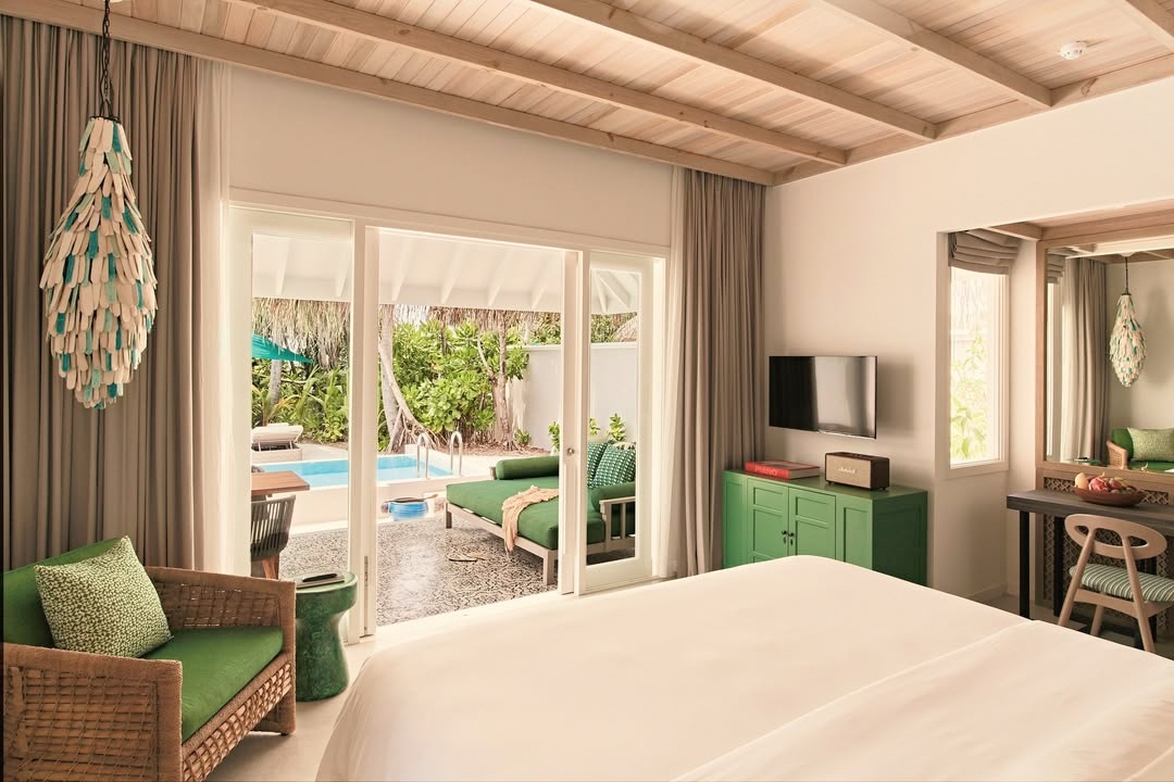 A beach villa interior. The retro-chic palette runs through the furnishings, the textiles, and the lighting without becoming a costume.