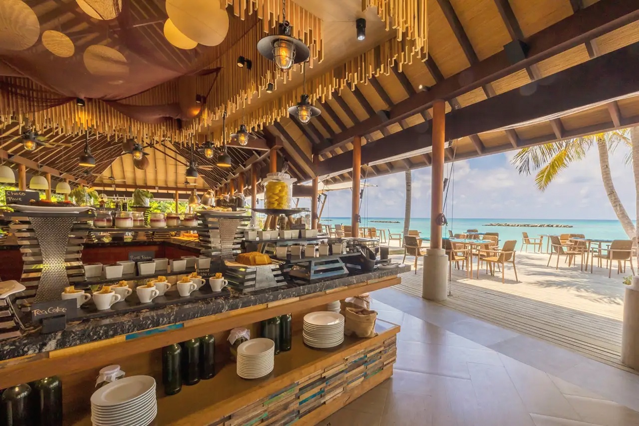 Dining at the water's edge. The main restaurant sits close to the lagoon, with open-sided seating and views across the reef.