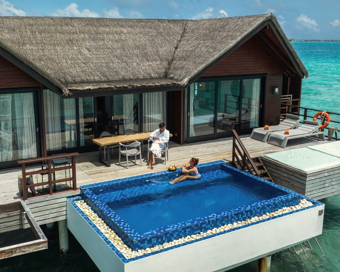 An overwater pool villa from the deck. The lagoon sits directly below, accessible by ladder from the deck edge.
