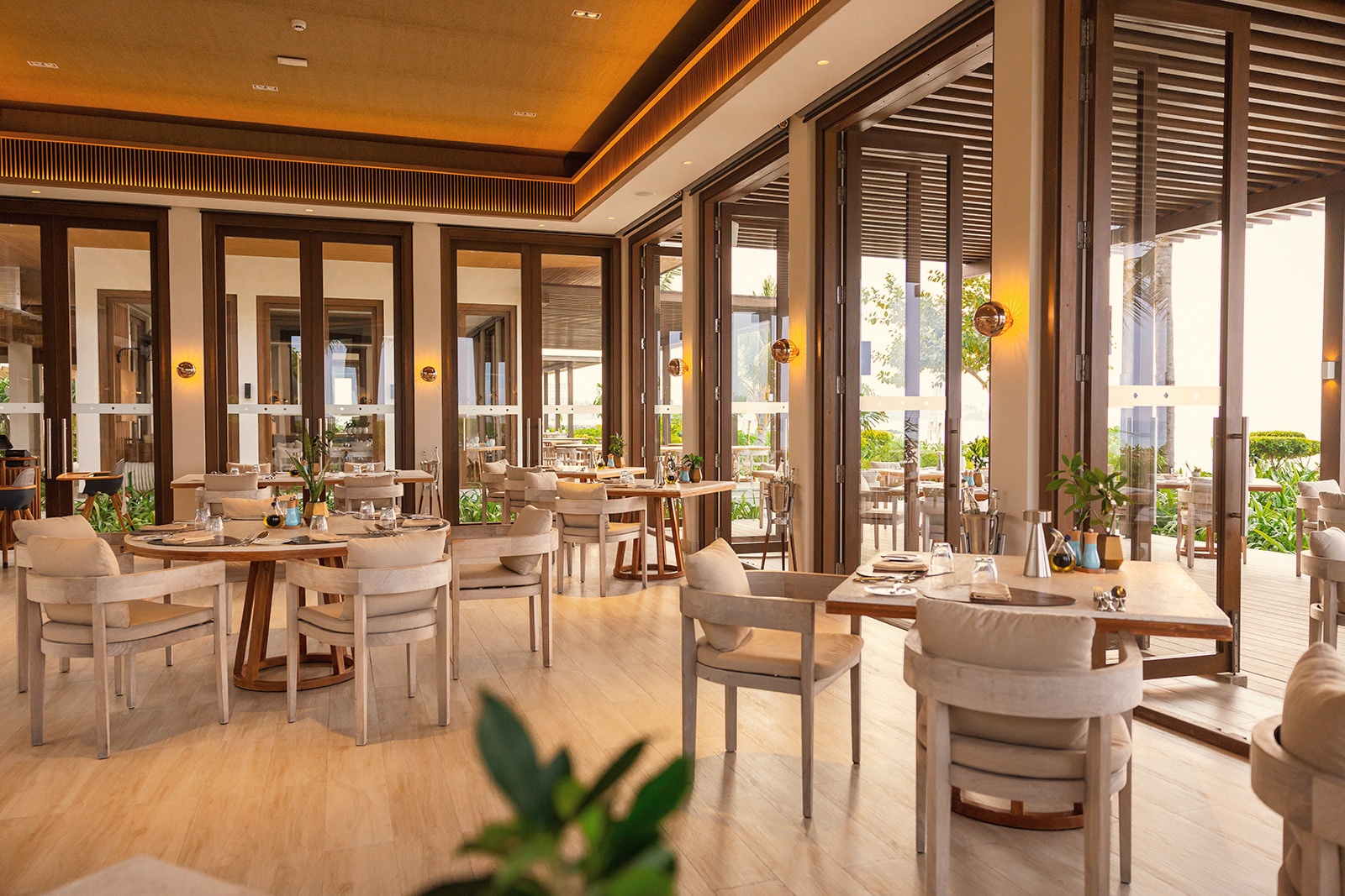 Dining at the water's edge. Tables set at the resort's main restaurant, the lagoon visible from every seat.