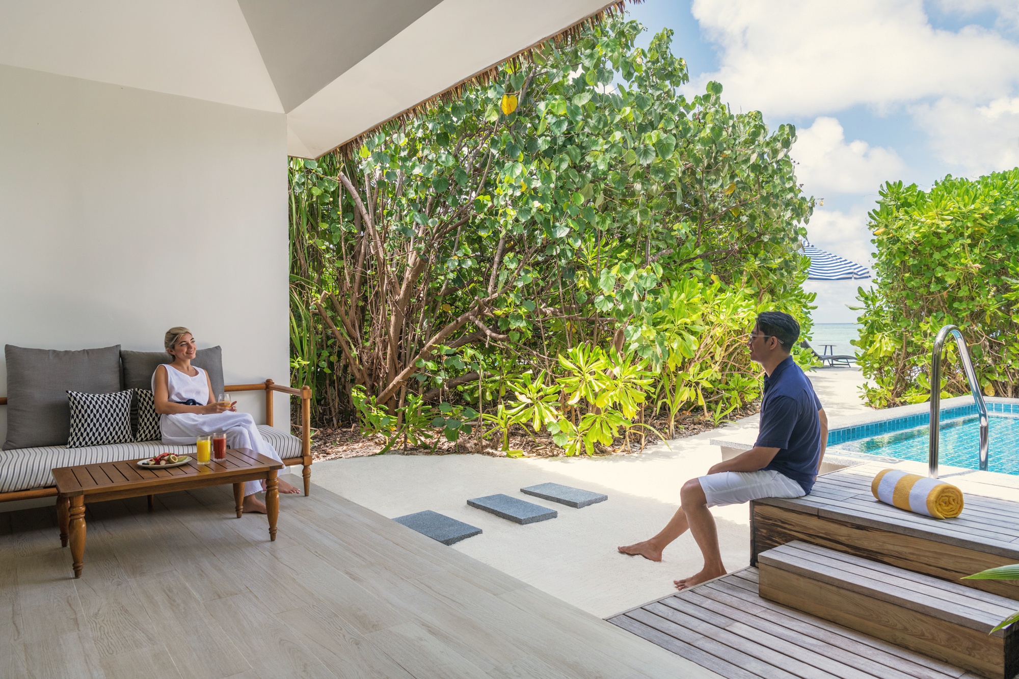 The lagoon edge from a beach villa pool. The transition from pool to beach to reef is the defining spatial experience of the island.