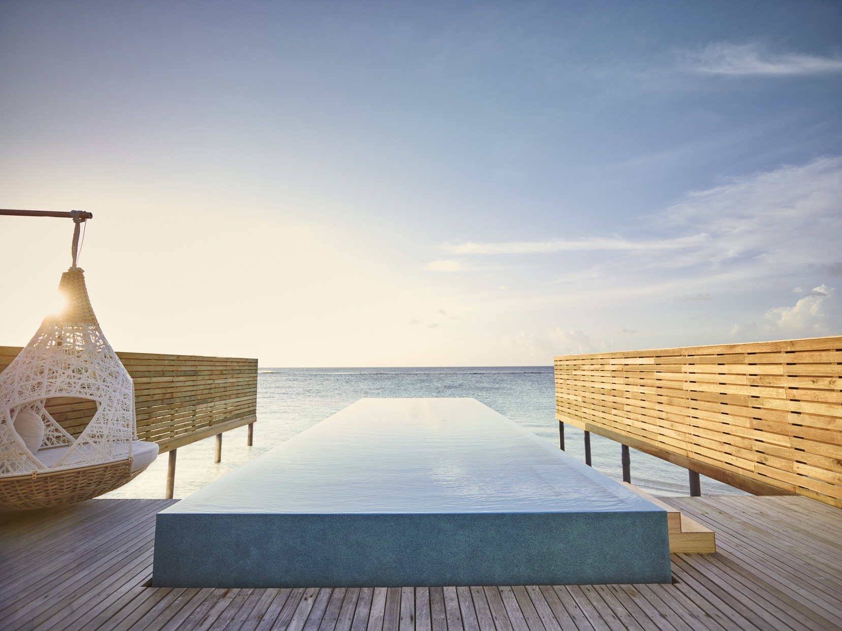 An overwater pool villa from the deck. The lagoon edge is its own room, with direct water access and an unobstructed view across the atoll.