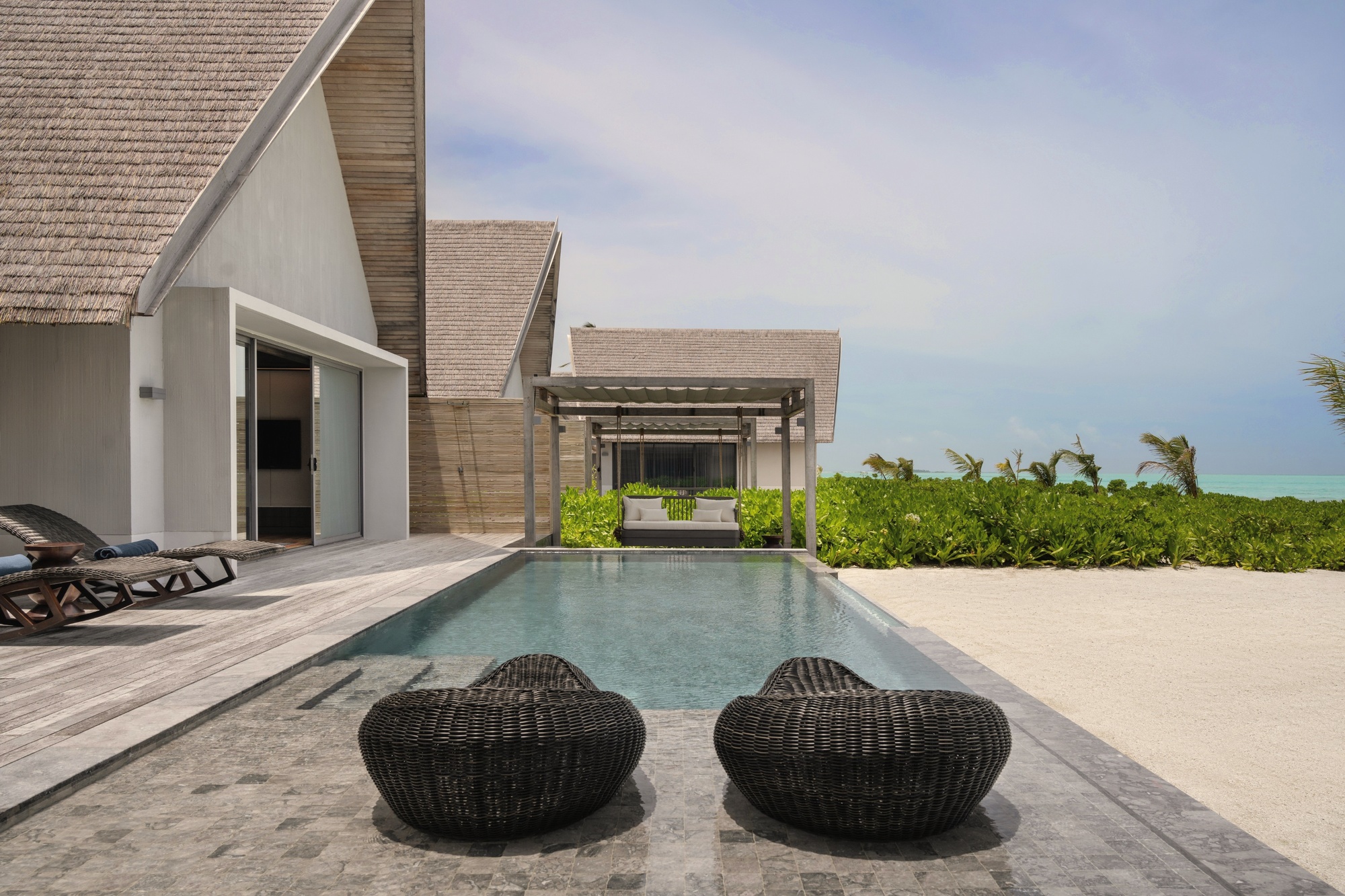 A beach pool villa at the lagoon edge. The sunrise-facing orientation means the first light arrives directly across the water and onto the deck.