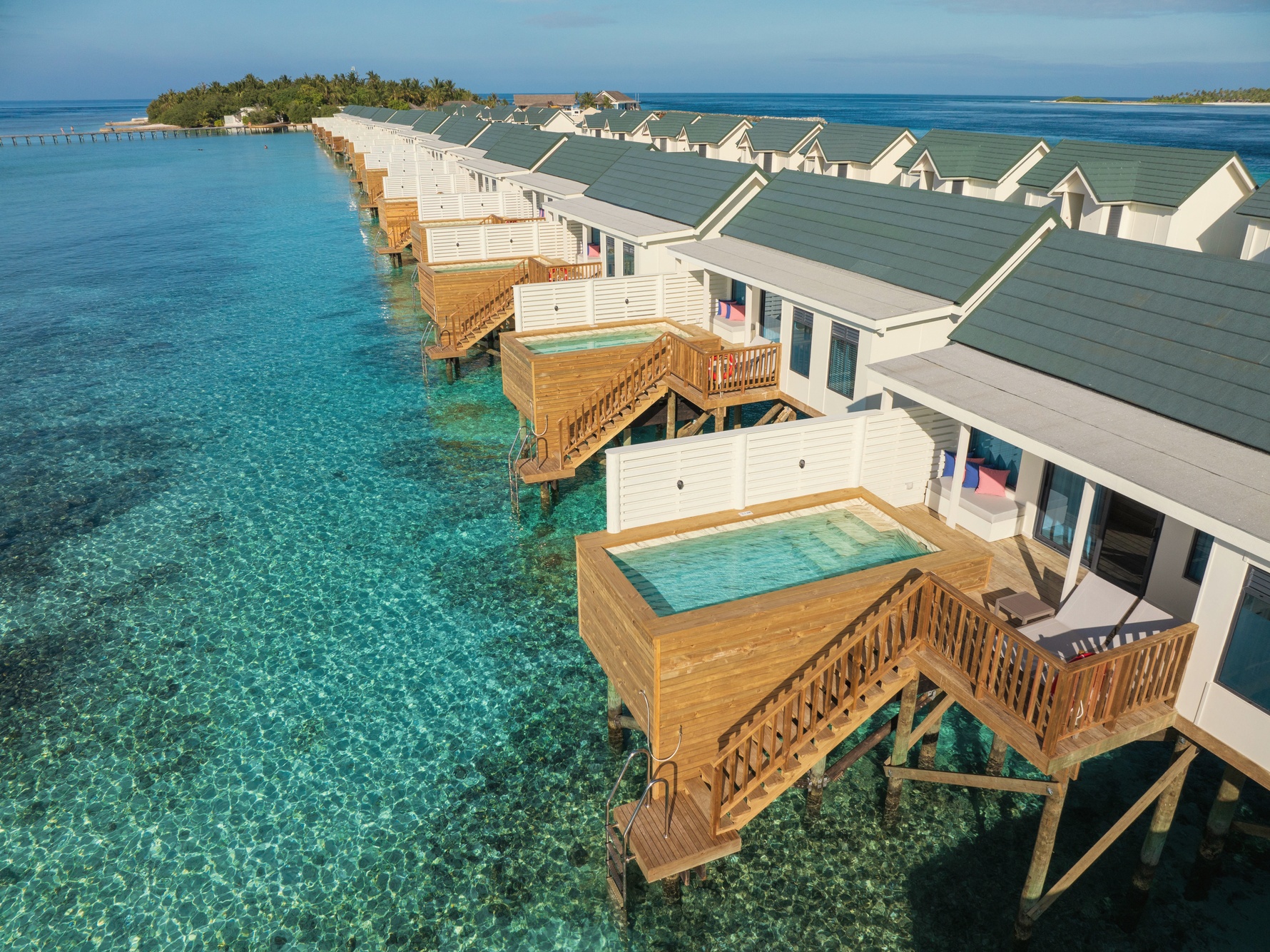 A water villa from the deck. The lagoon edge is its own room, with direct access to the reef below.