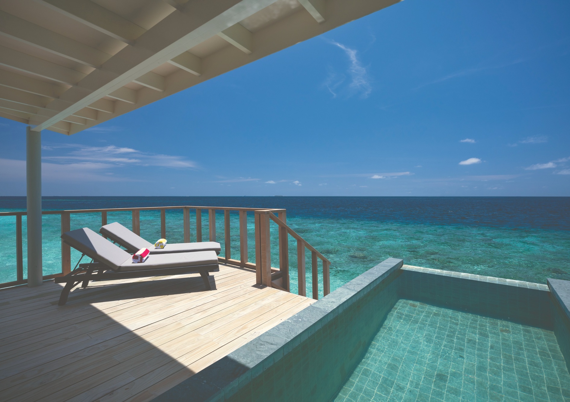 Inside a Sunnest overwater villa. The pool sits at the edge of the water, with the lagoon directly below.