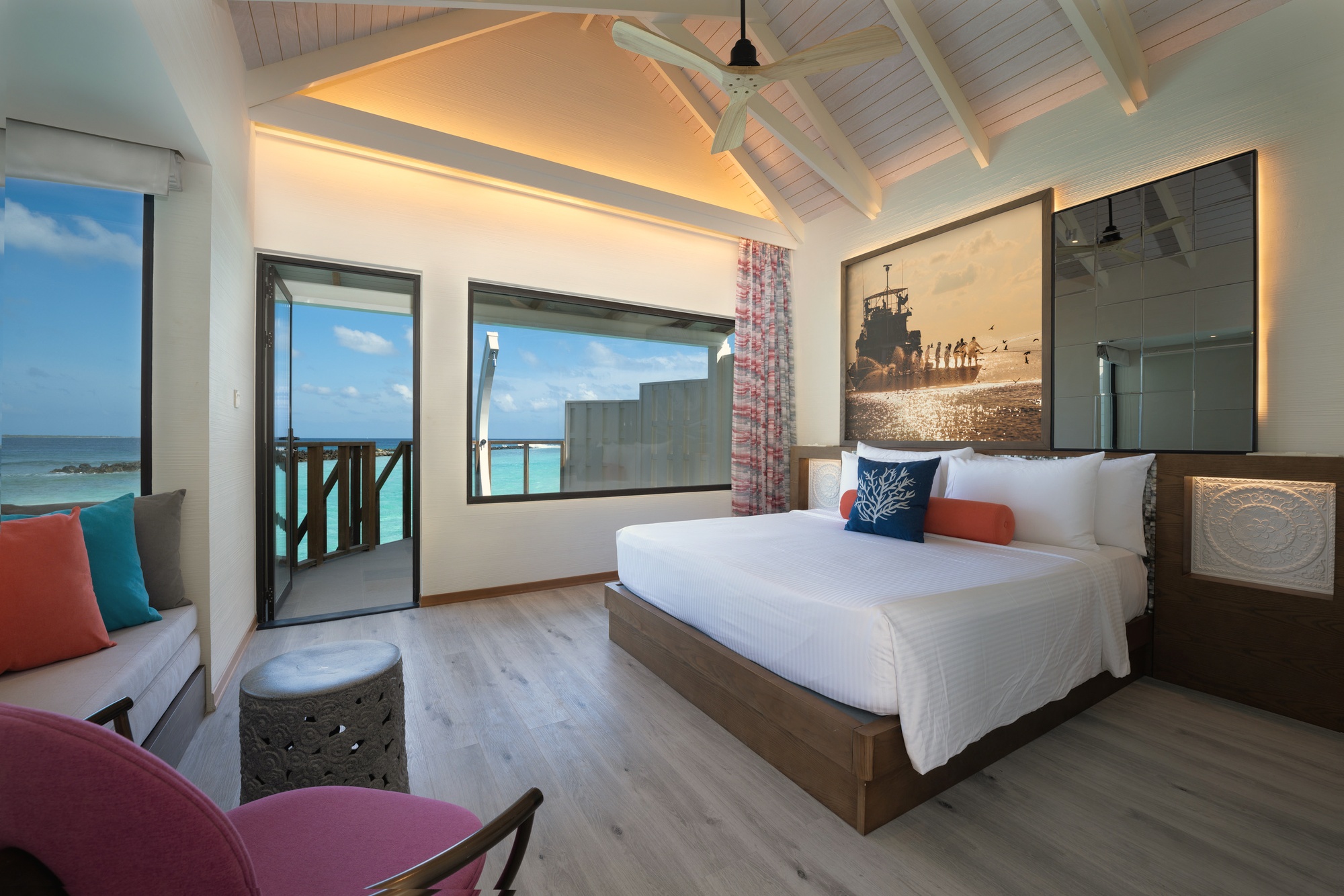 Inside an overwater pool villa. The private pool occupies the deck, with the lagoon visible beyond the rail.