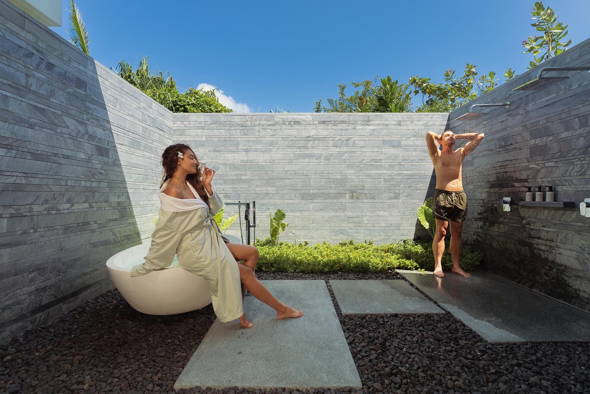 The spa treatment room. Natural materials, a single bed oriented toward the lagoon, natural light from a full-length window.