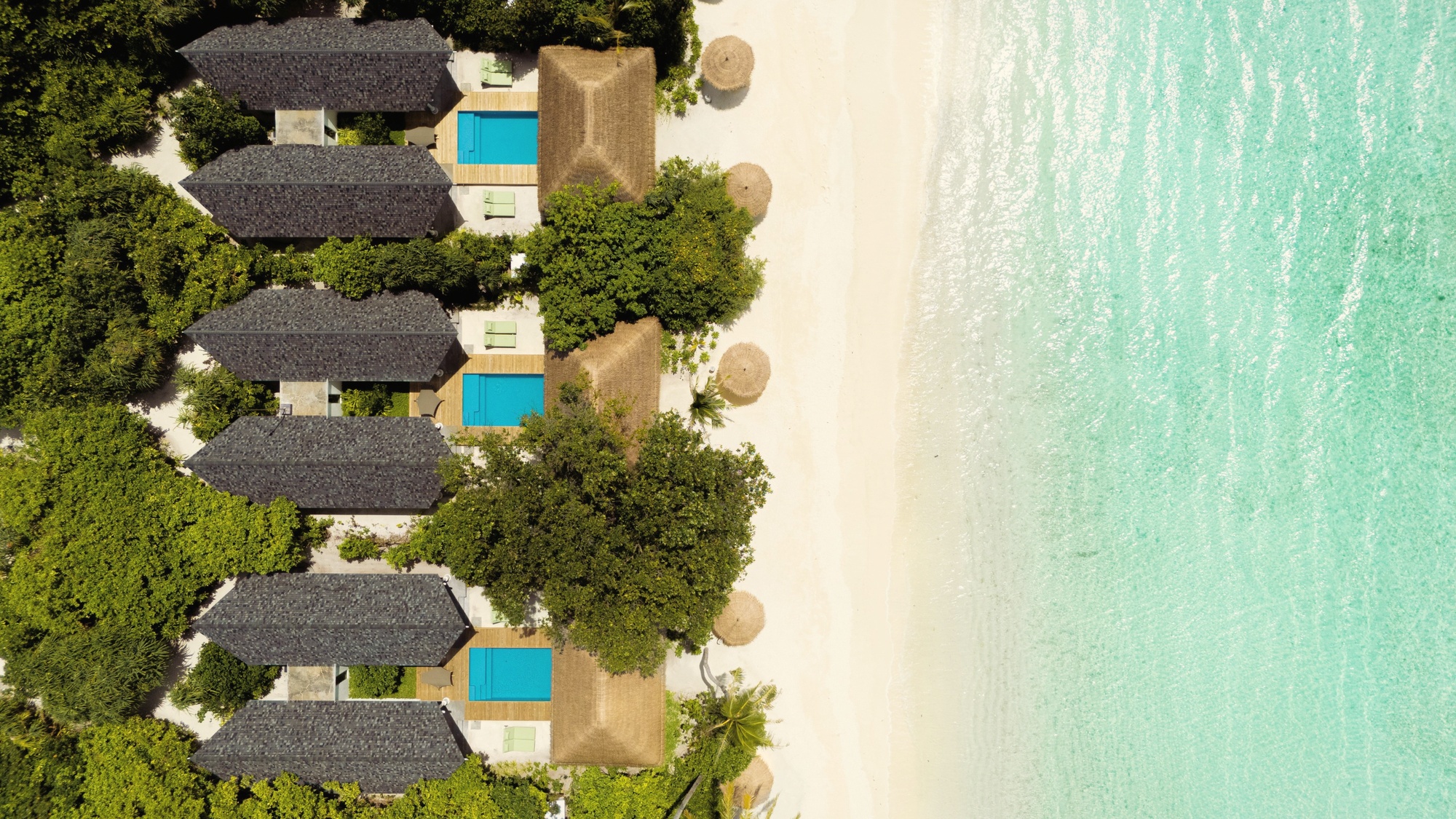 Kudakurathu Island from above. The resort occupies its own island in Raa Atoll, the scale of 167 villas visible across the tree line and lagoon edge.