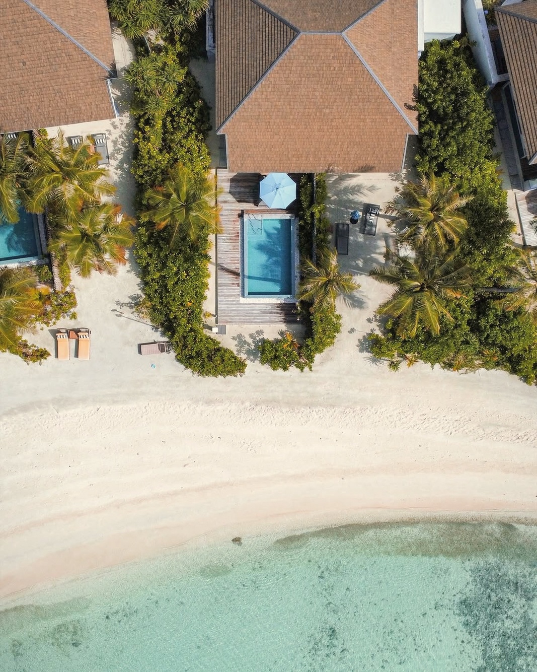 The lagoon edge from a beach villa. Direct sand access, the South Malé reef visible in the shallows.