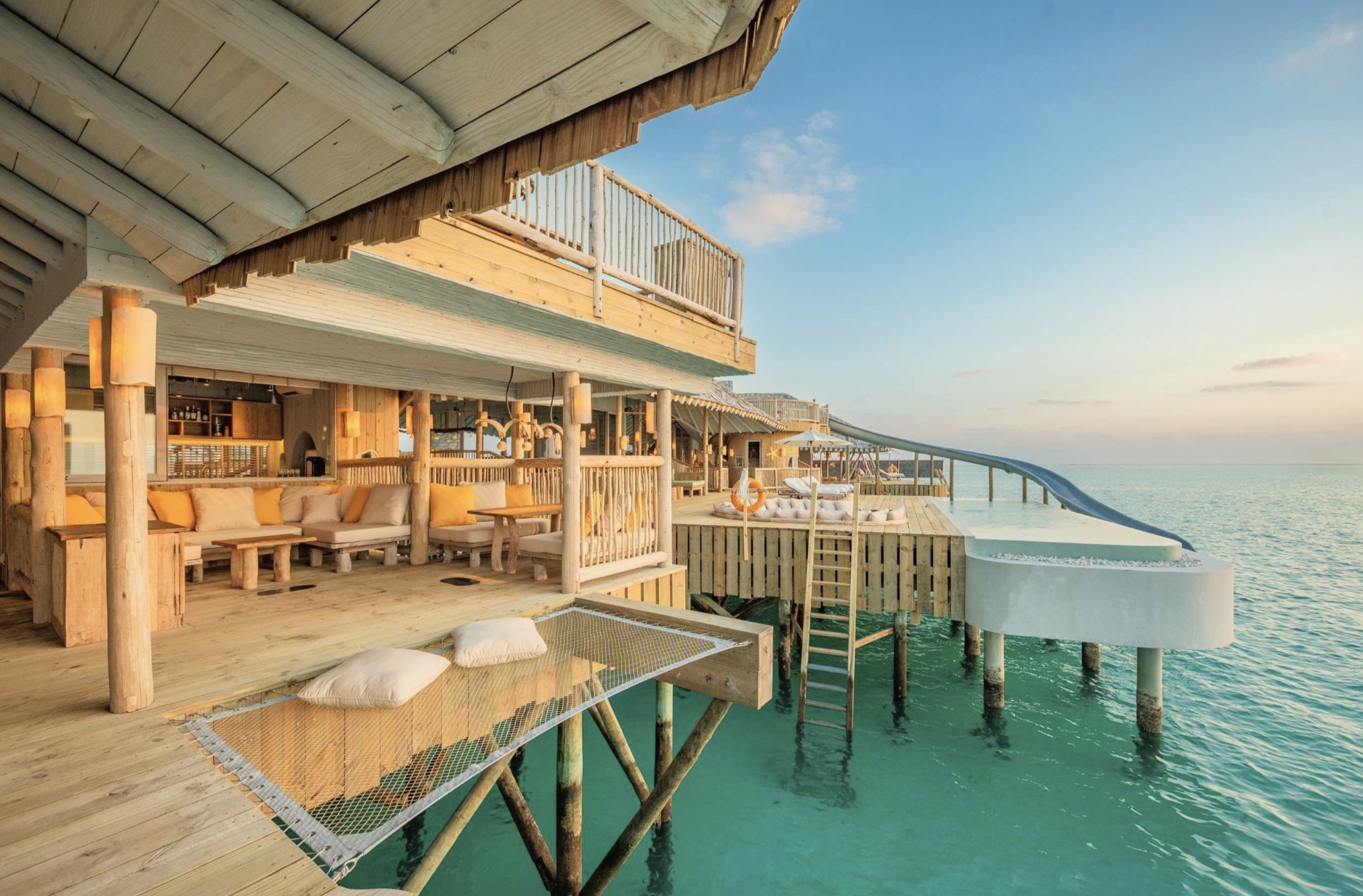 An overwater villa at the edge of the reef. The horizon is unbroken in every direction.