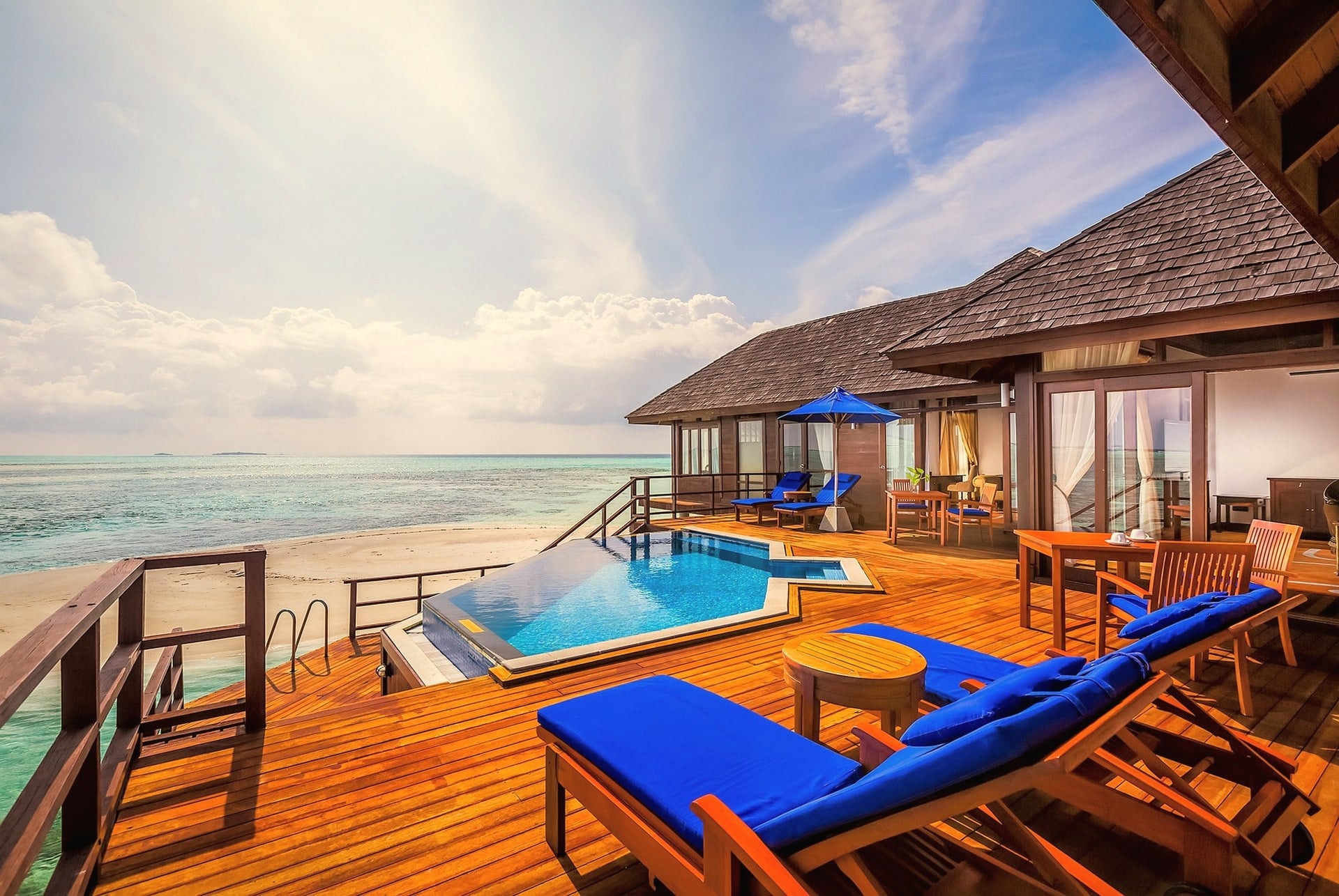 An overwater villa from the deck. The lagoon stretches out directly below, with the villa's private access point visible at the edge of the platform.