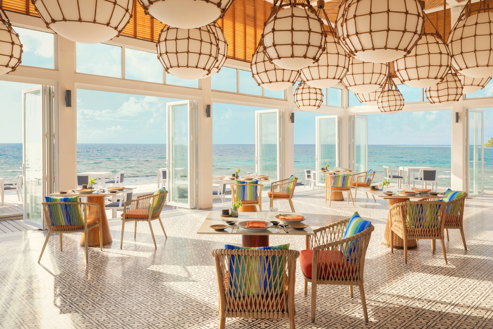 Dining on the island. A table set at the water's edge as the light drops over the southern atoll.