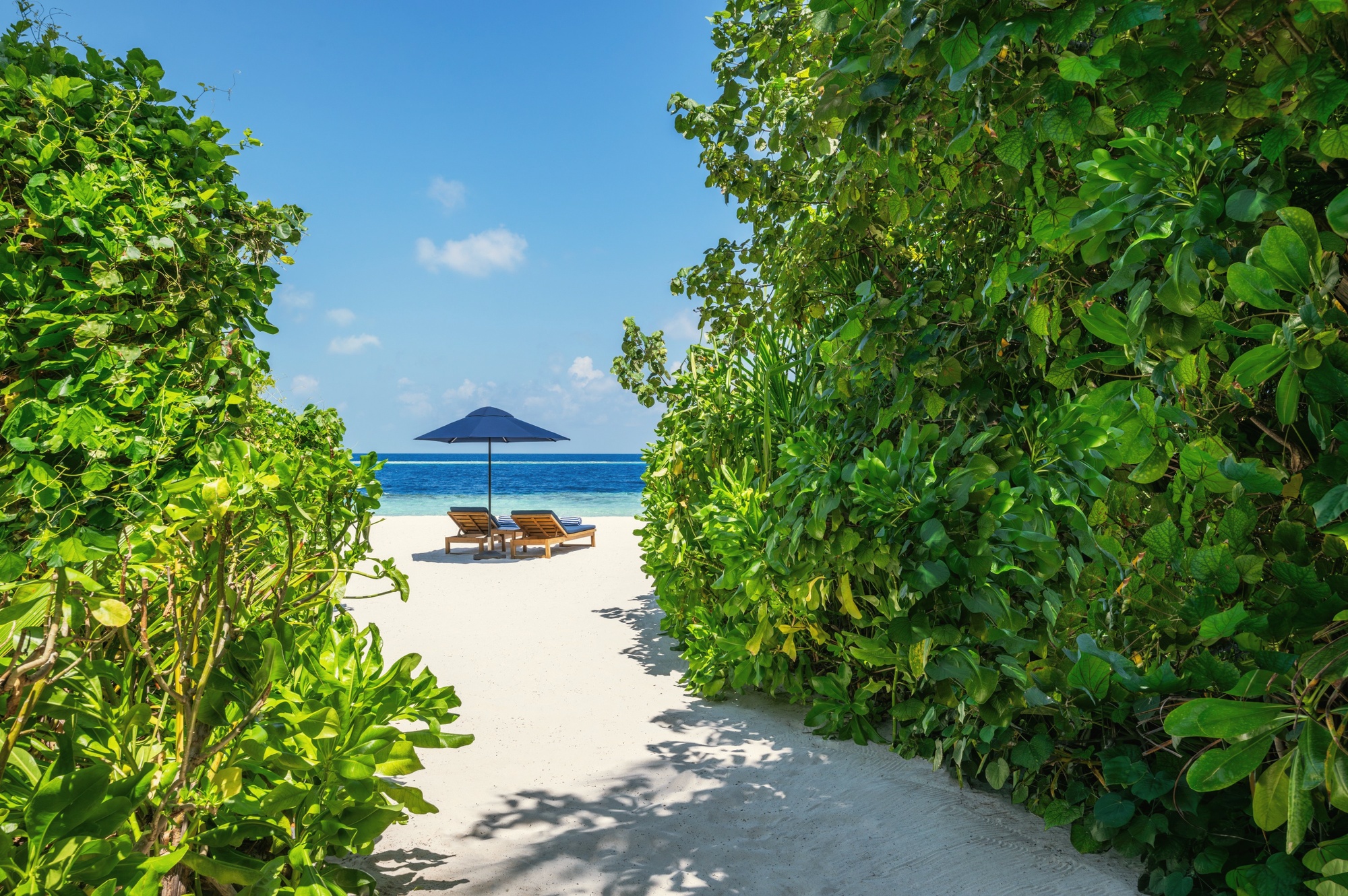 An Oceanfront Beach Pool Villa from the sand. The colonial-inspired facade opens directly onto the beach, with a private pool set between the villa and the water.