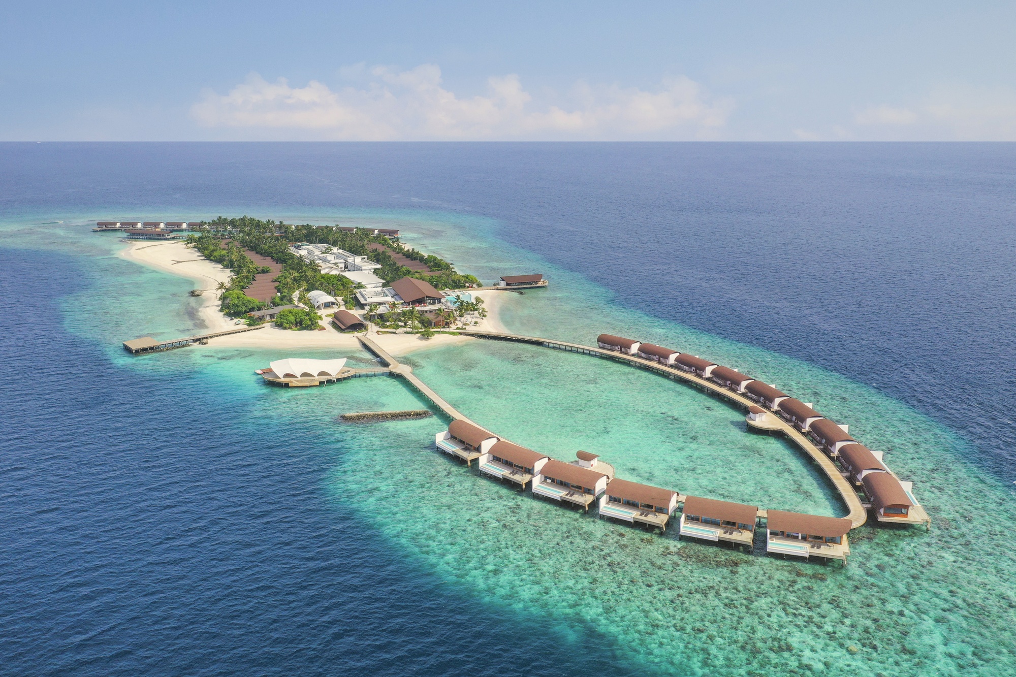 Miriandhoo Island from above. The resort occupies its own private island in Baa Atoll, with the lagoon visible on all sides and the reef edge clearly defined from the air.